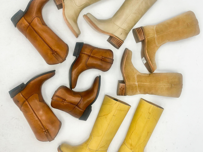Various styles and colors of Frye boots arranged on the floor and shot from above.