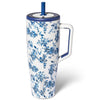 A tall insulated travel mug with a blue floral pattern on a white background, featuring a white handle, a blue lid rim, and a blue straw, shown on a clean white background.