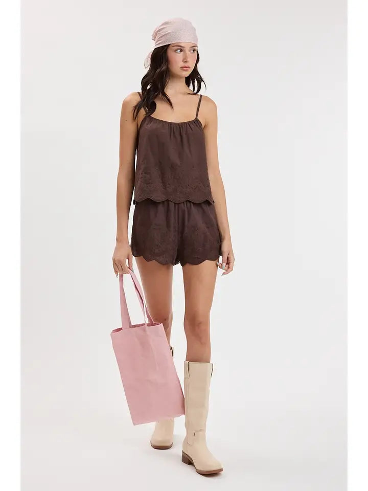 woman standing on white background wearing brown eyelet matching set and boots