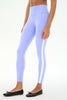 A model wearing light periwinkle blue high-waisted leggings with a white side stripe, paired with black ballet flats, against a plain white background.
