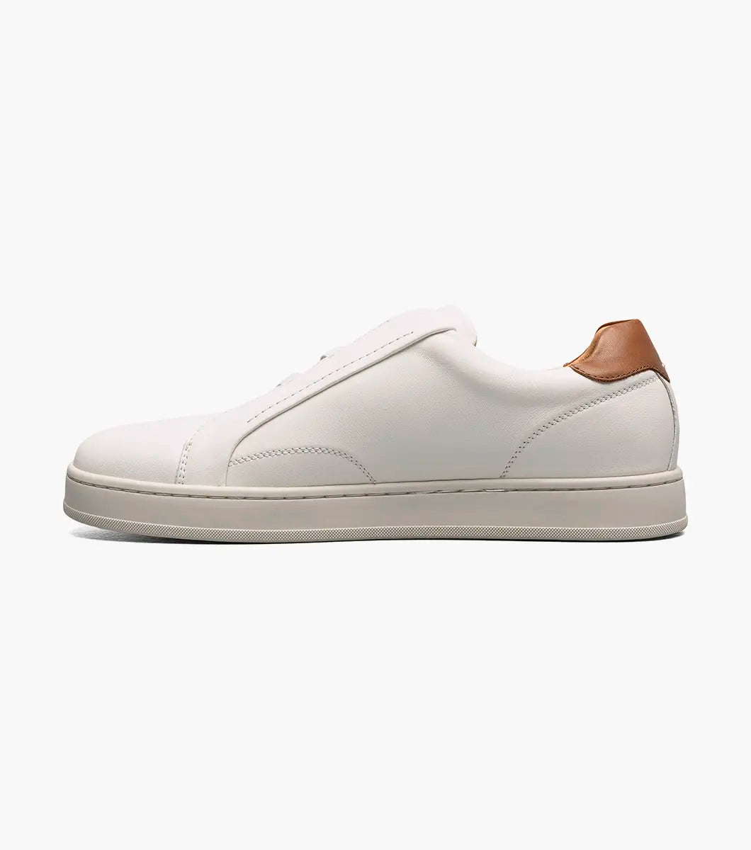 A low-top white leather sneaker with a light brown leather heel tab, shown in a side profile on a light gray background.