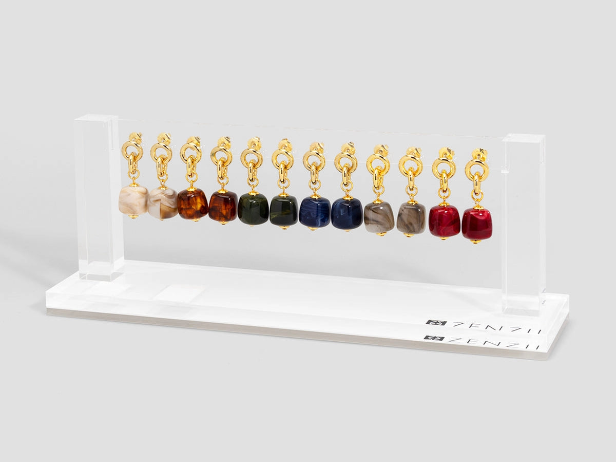 a display of earrings hanging on an acrylic  bar