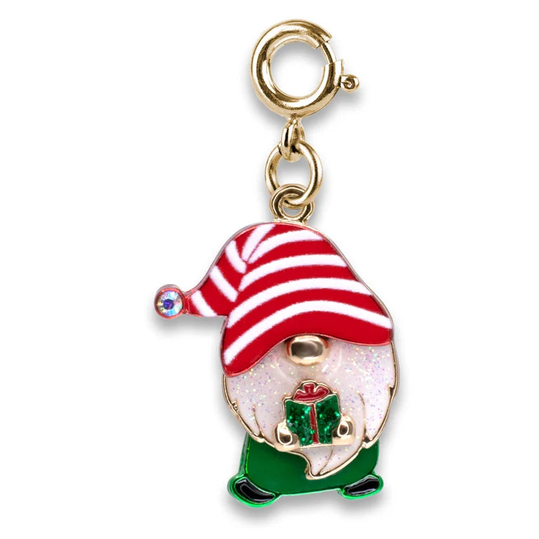 A Christmas gnome charm with a gold-tone clasp, featuring a red and white striped hat, a white face, green pants, and a small green gift box, set against a plain white background.