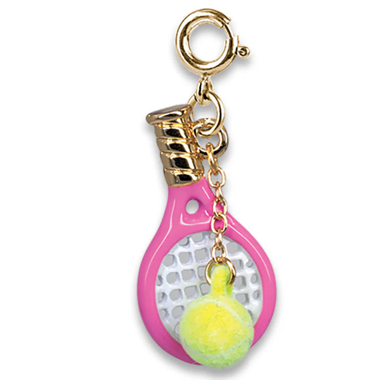 A tennis racket-shaped keychain charm with a pink frame, gold-tone metal hardware, and a small yellow tennis ball dangling from the handle, shown on a plain white background.