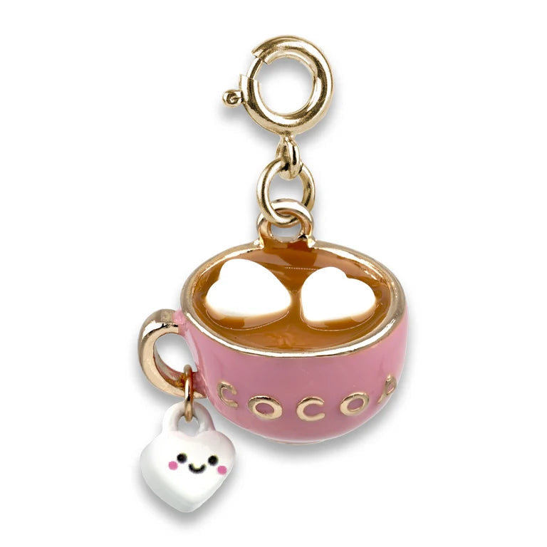 A pink enamel hot cocoa cup charm with gold-tone metal trim, a clasp at the top, and a dangling white heart-shaped charm with a smiling face. The cup is filled with brown cocoa and has the word 'cocoa' in gold letters on the side.