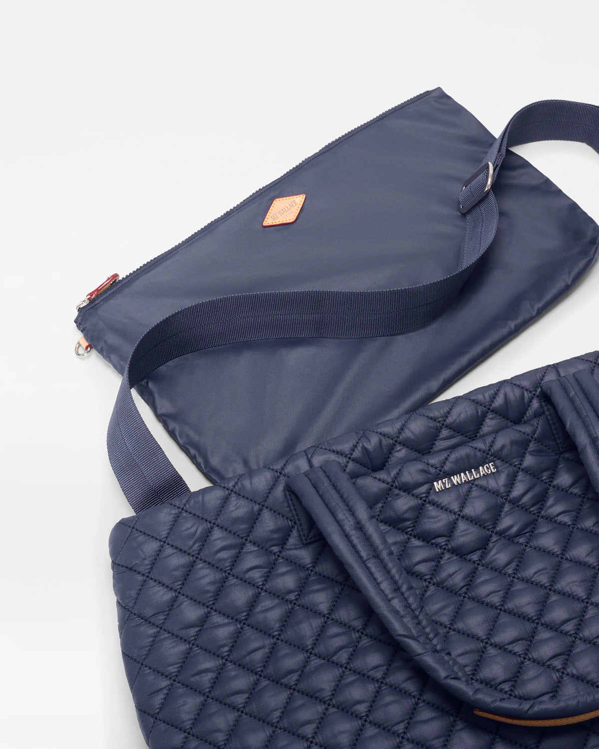 Navy quilted bag with a strap on a light gray background