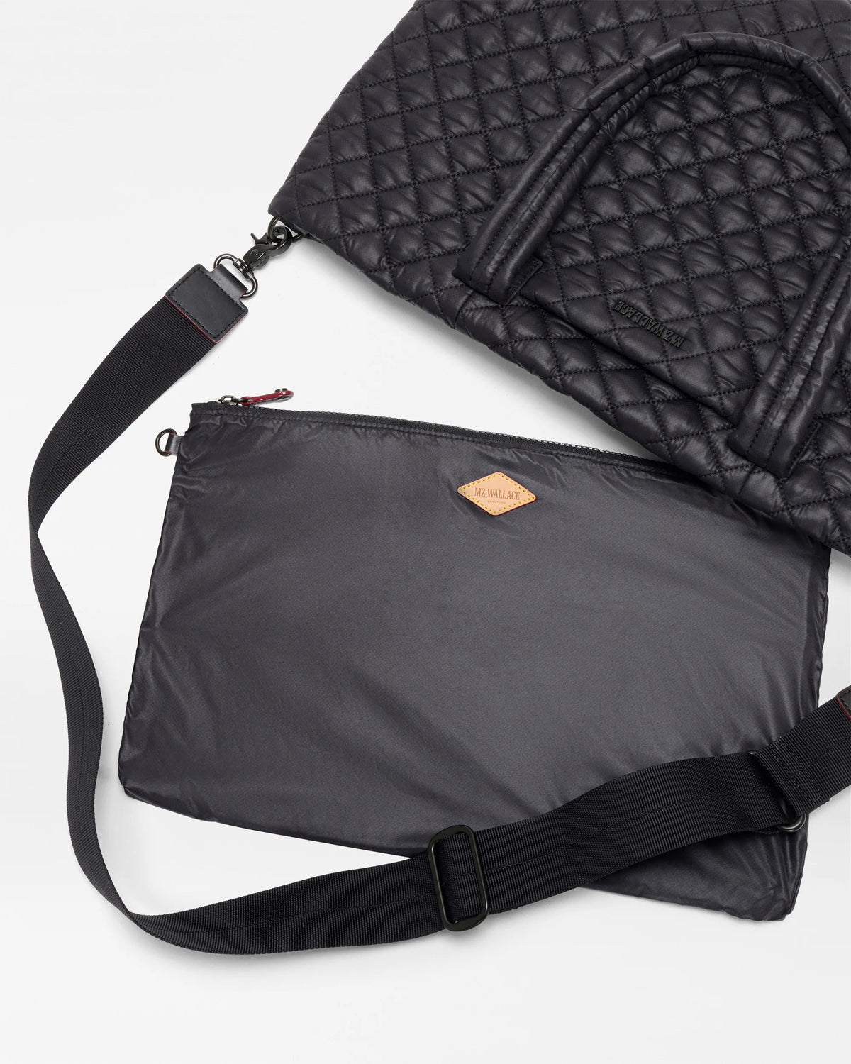 Black quilted bag with a strap on a white background