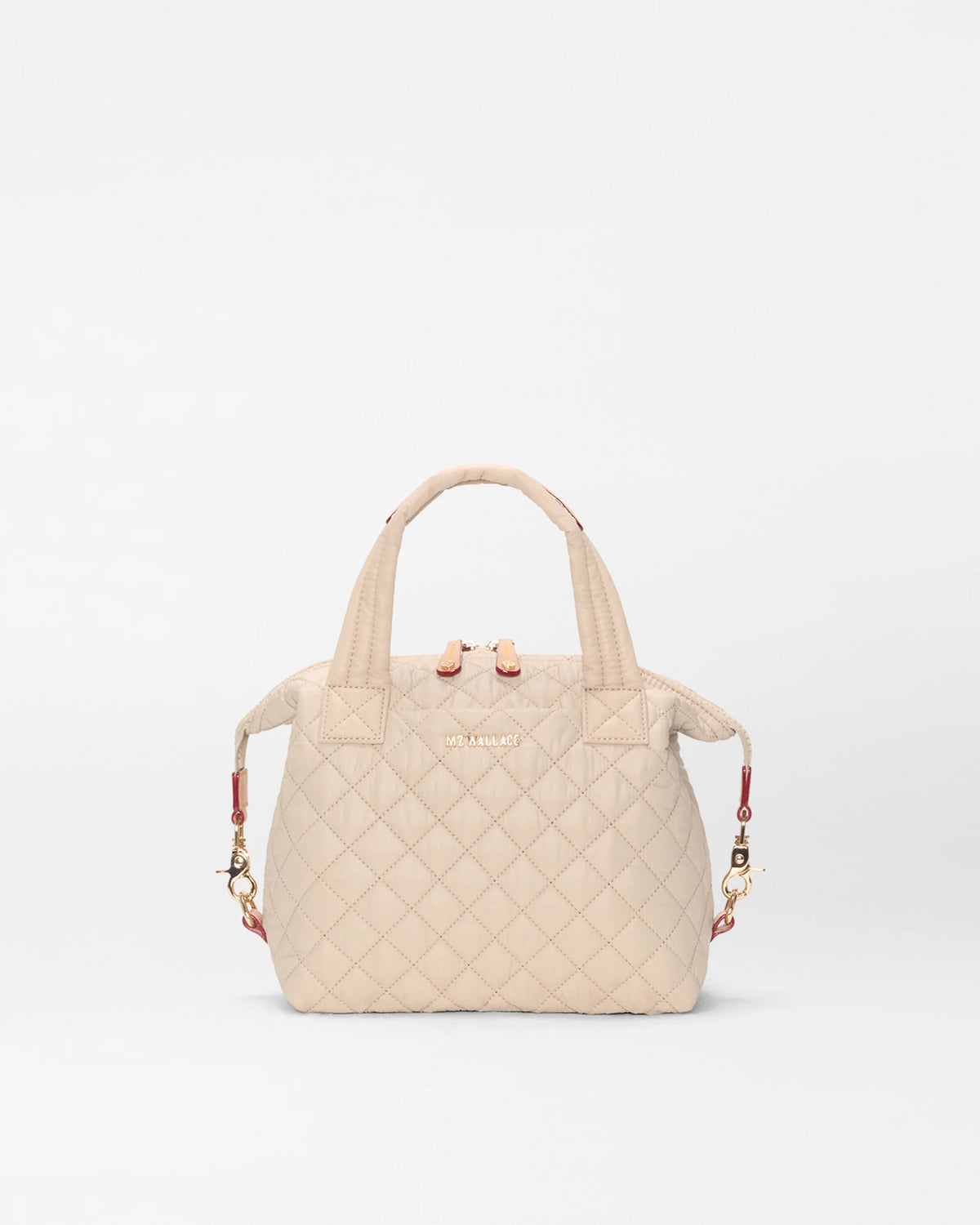 Beige quilted handbag with floral accents on a white background