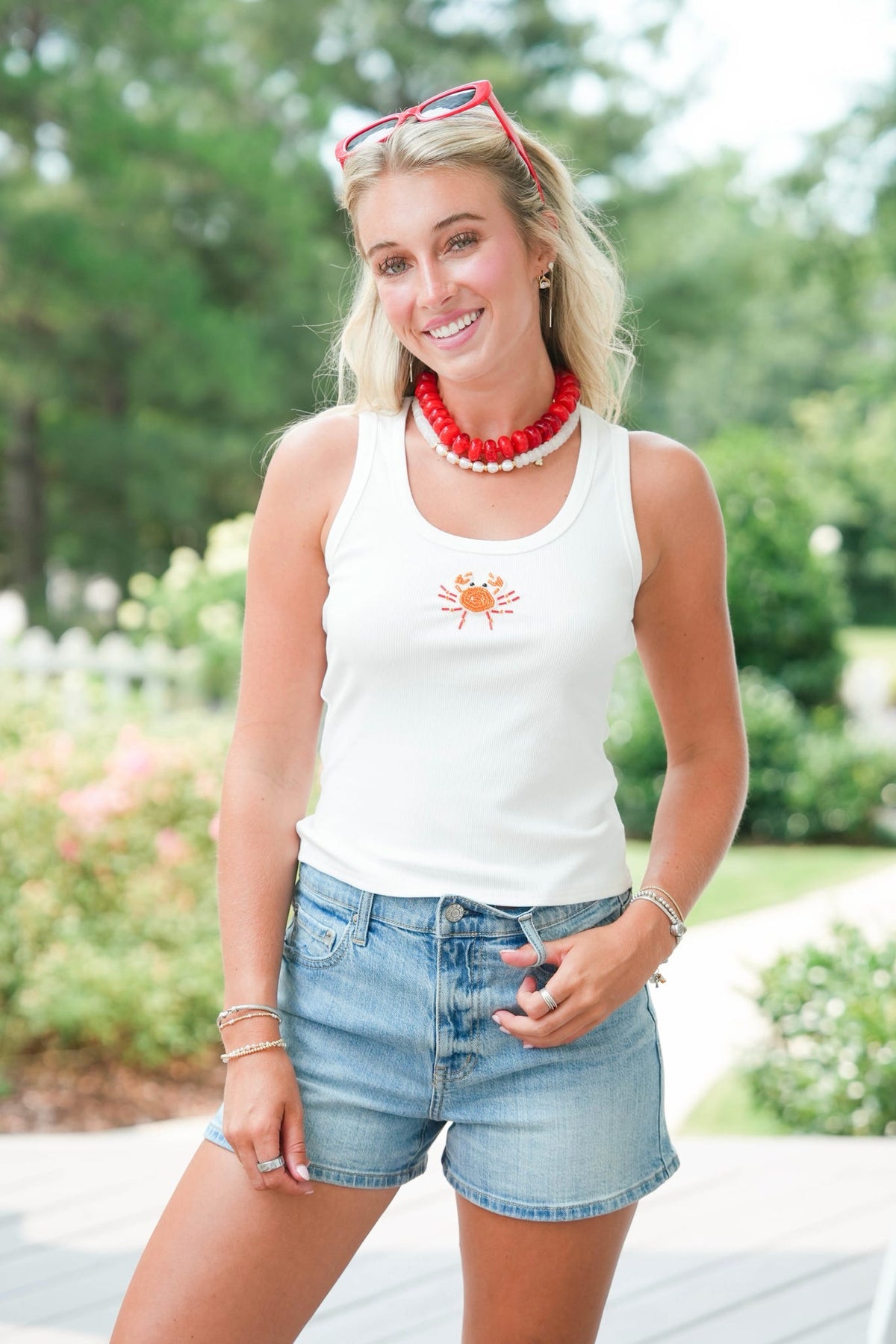 girl wearing white tank with beaded crab