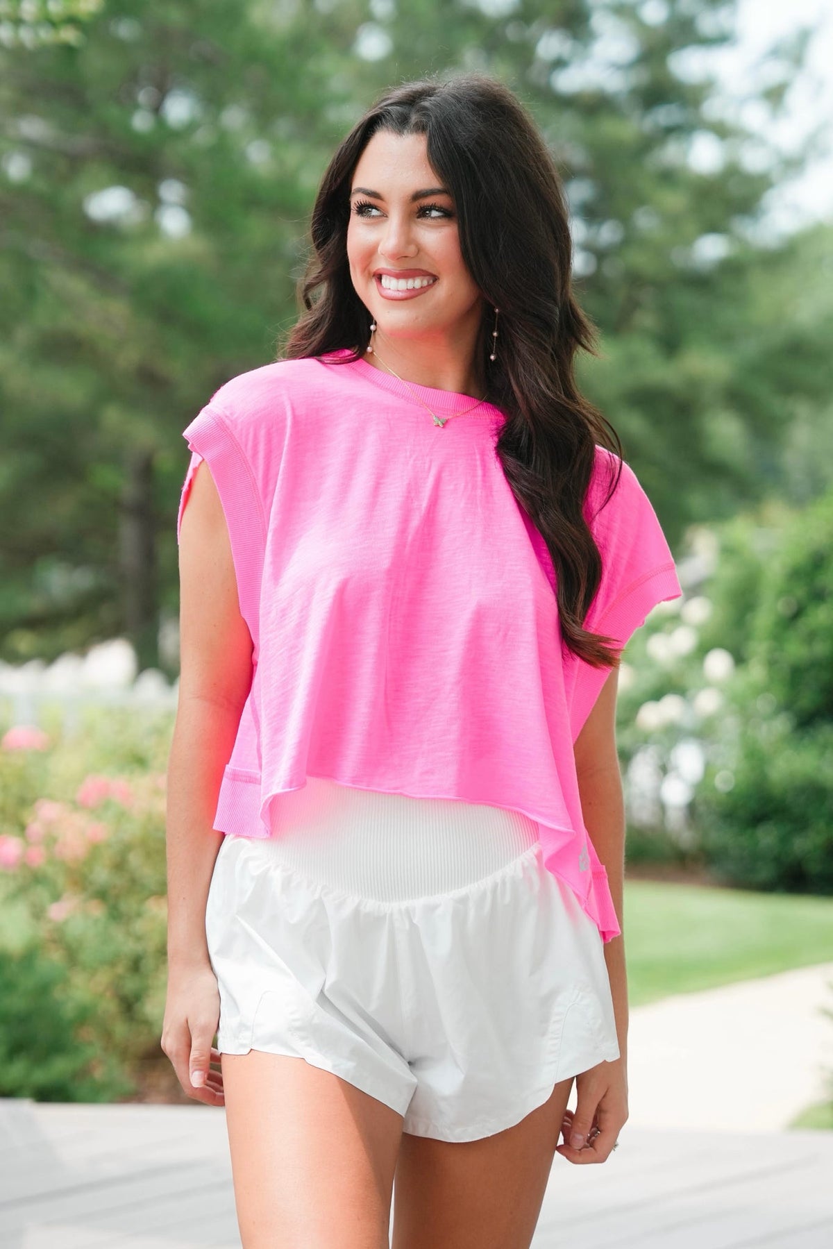 woman wearing hot pink top and white shorts