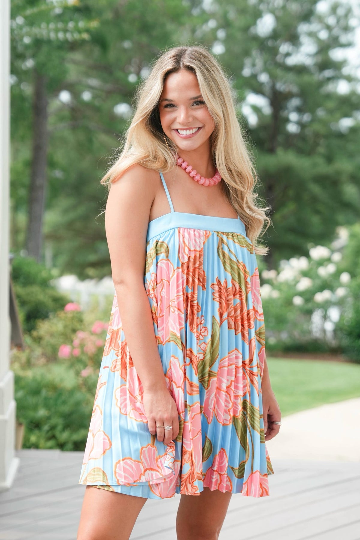 Woman wearing a colorful floral dress in an outdoor setting