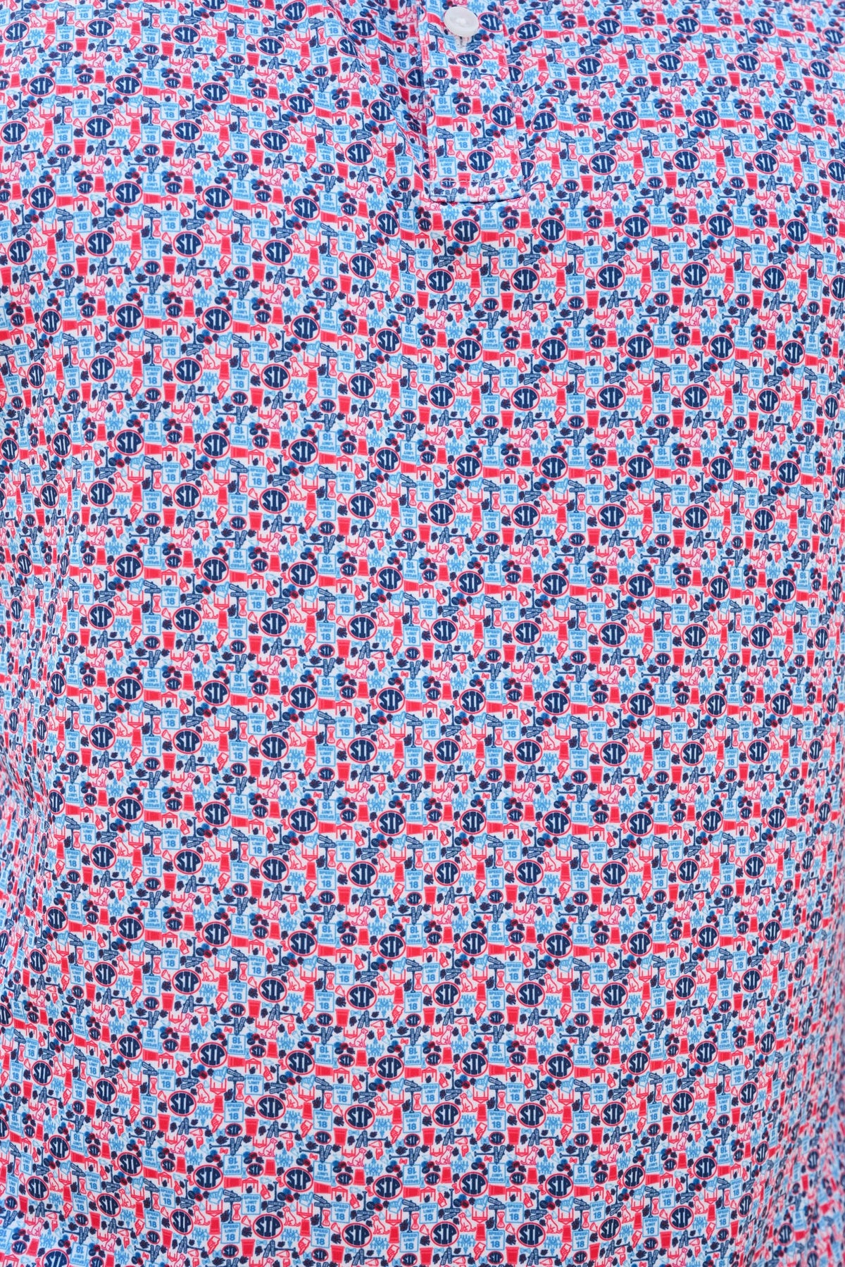 Close-up of a patterned shirt fabric with a small-scale repeating print in light blue, pink, and dark navy blue.