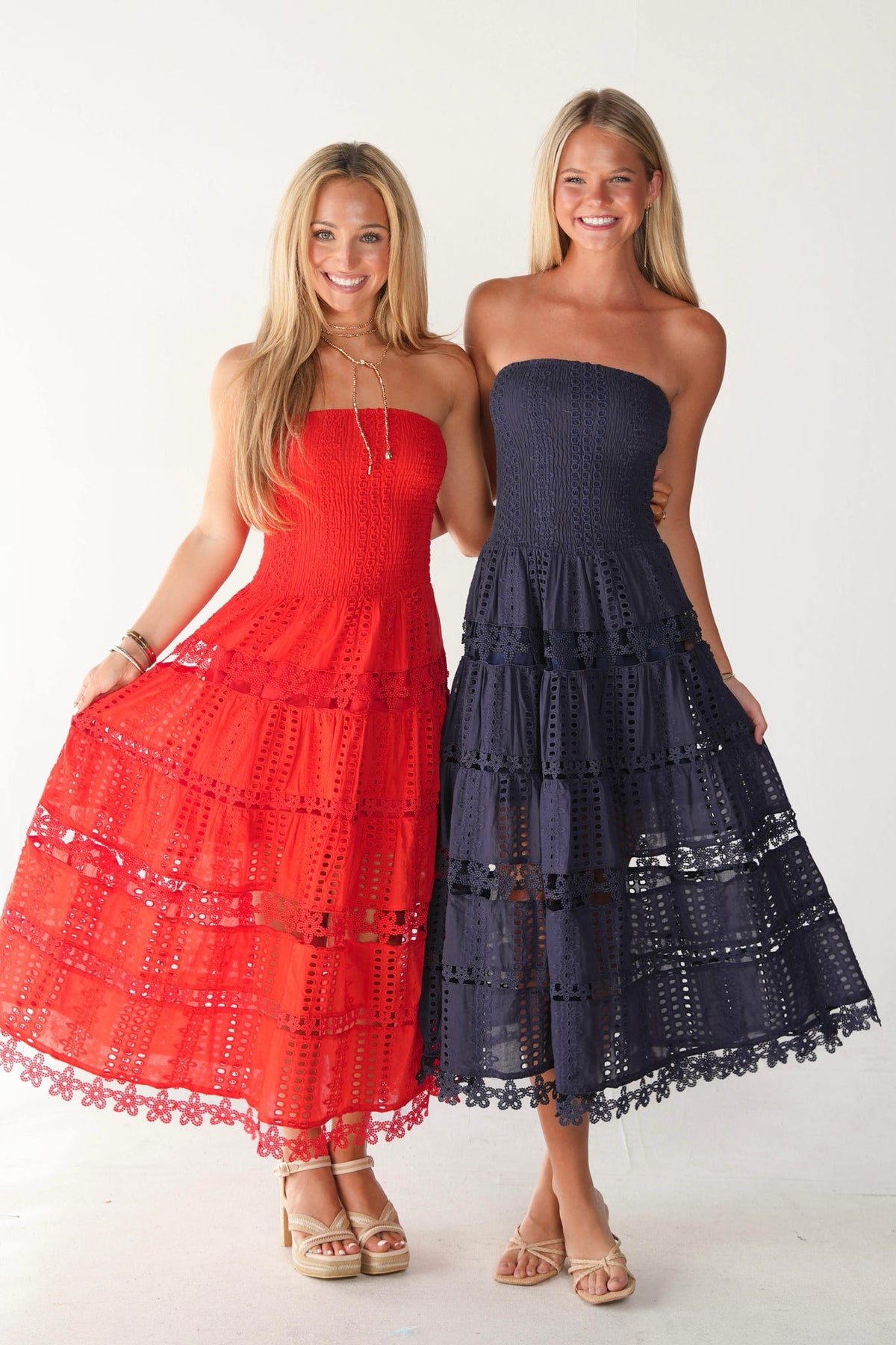 Two women modeling strapless midi dresses with eyelet lace.