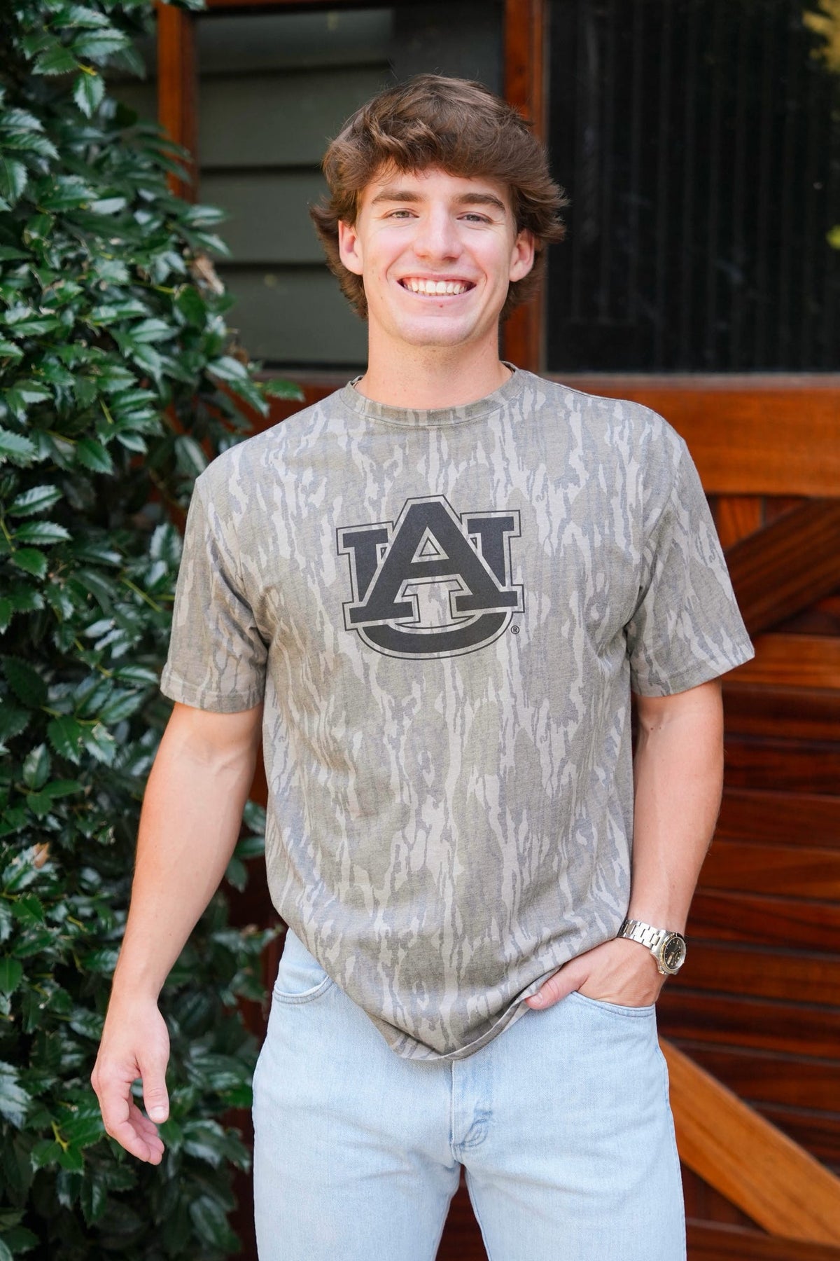 man modeling a camo t-shirt with an Auburn University logo on it