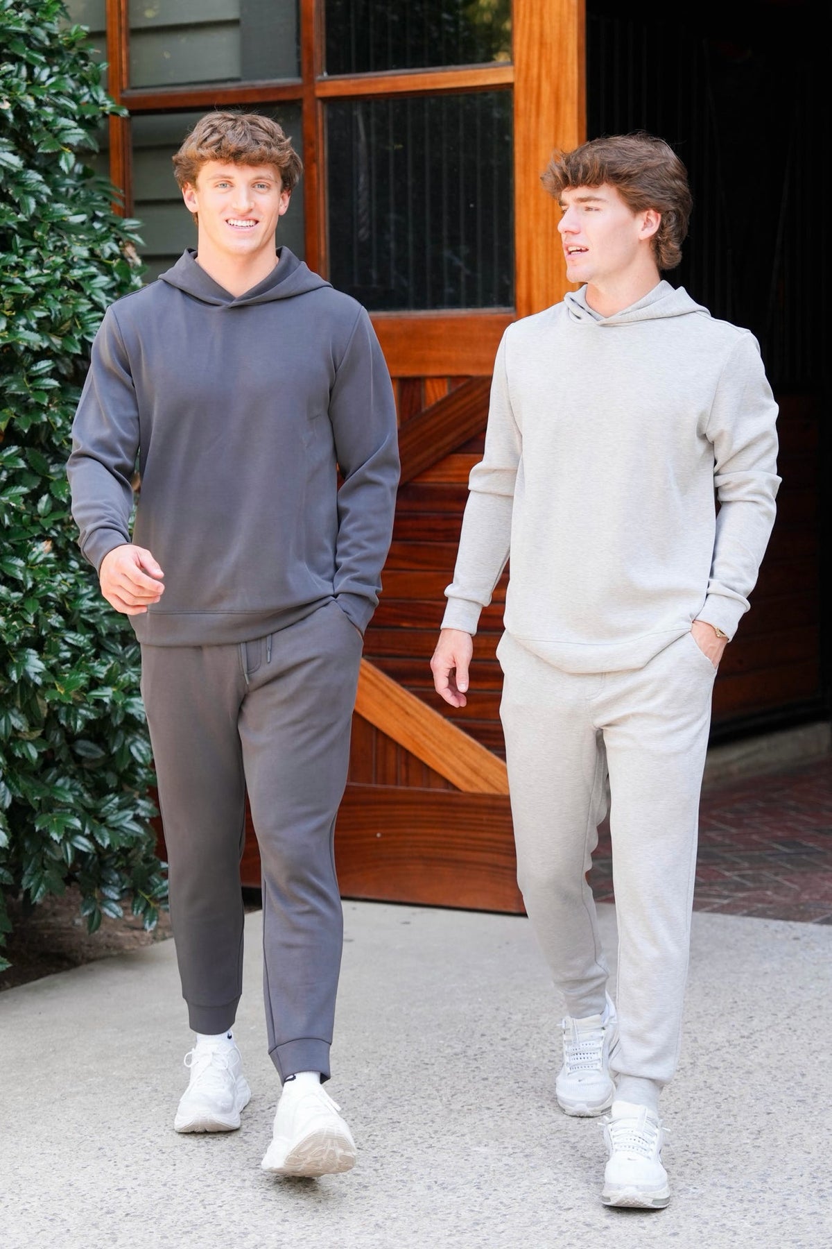 Two men modeling a dark grey and light grey sweat set