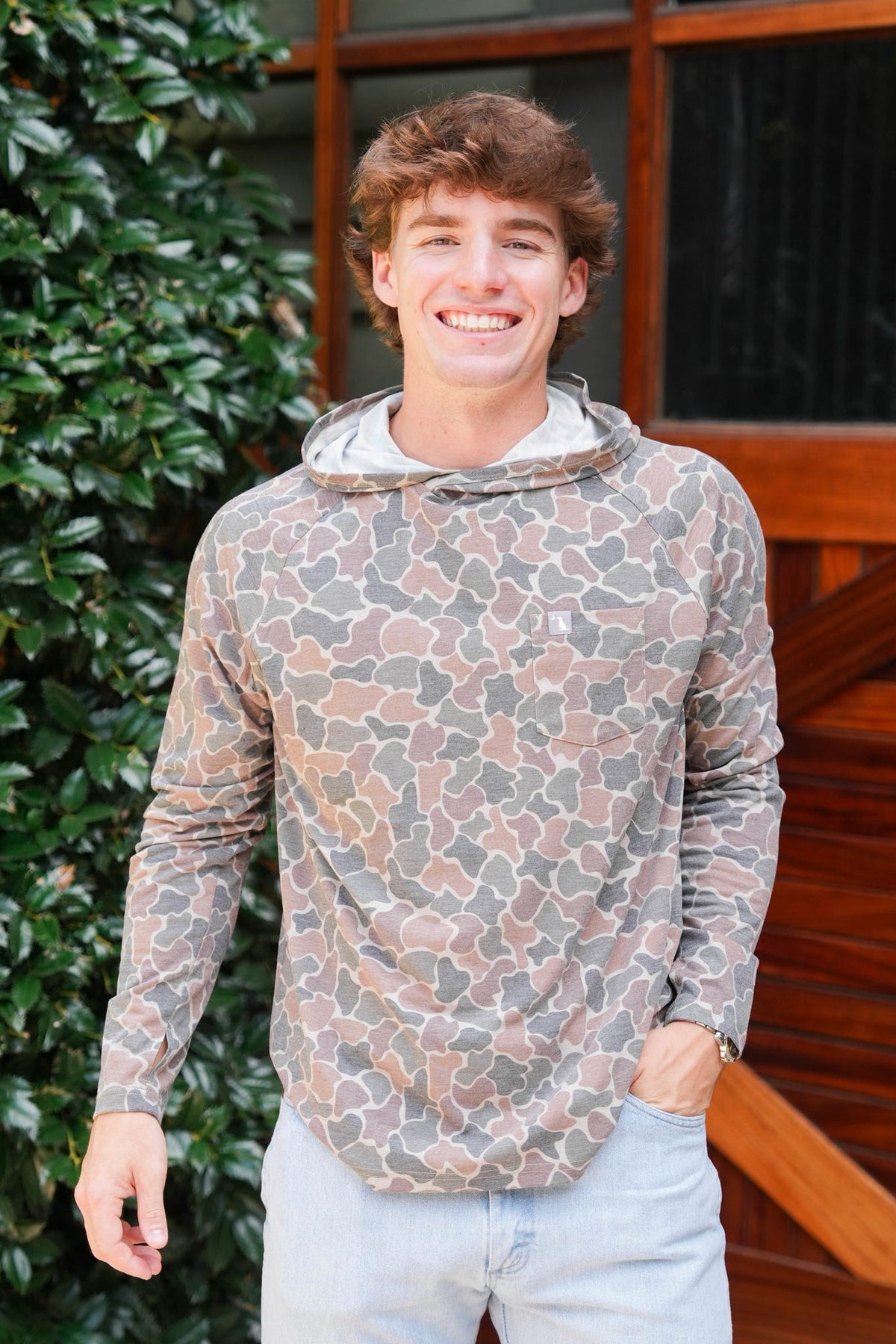 Man modeling camo hooded shirt.