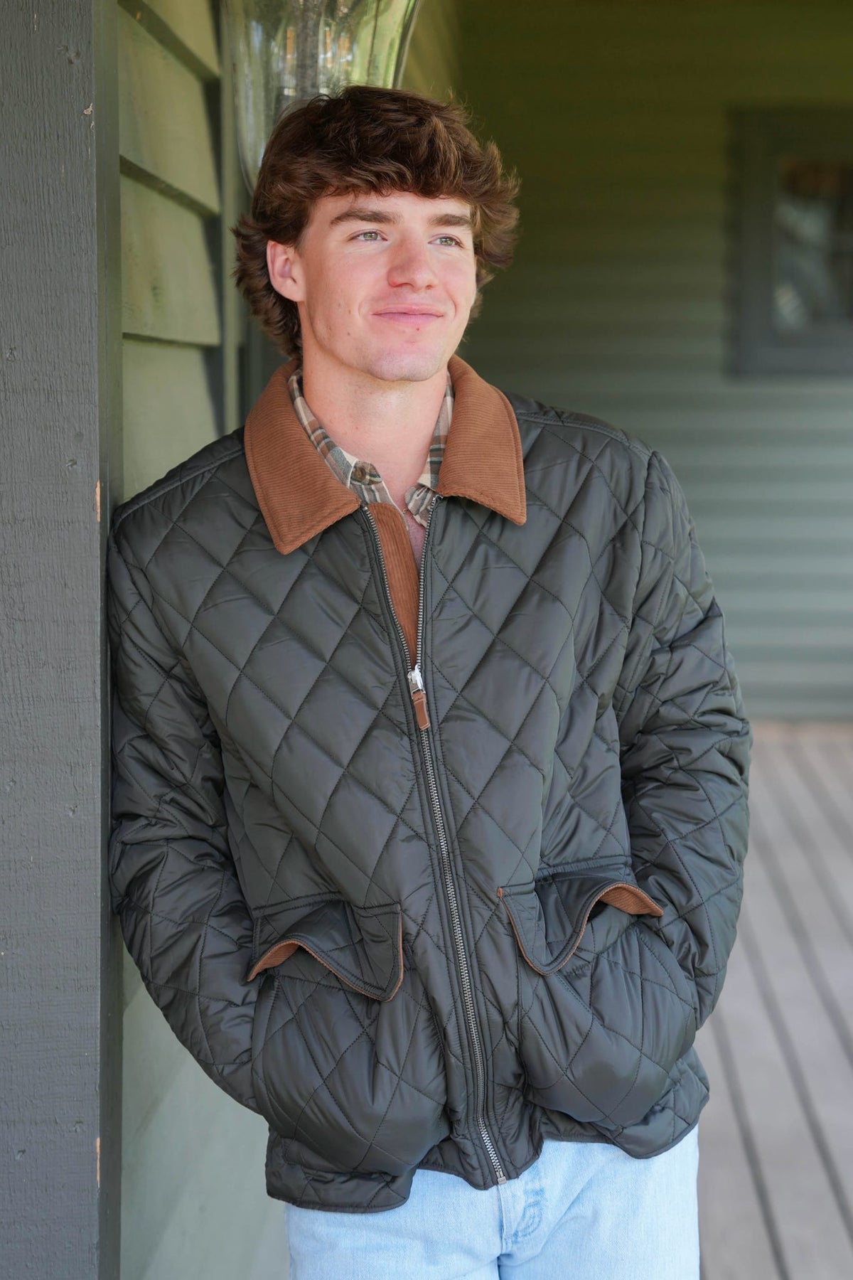 Man modeling dark colored quilted jacket