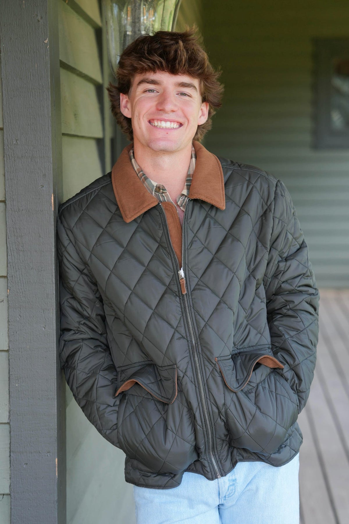 Man modeling dark colored quilted jacket