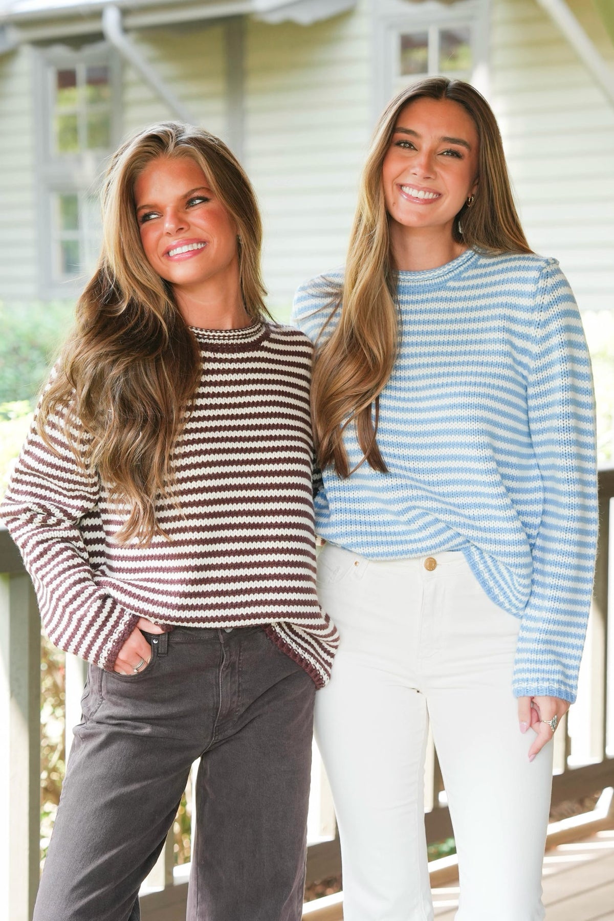 two women standing outside modeling two sweaters 