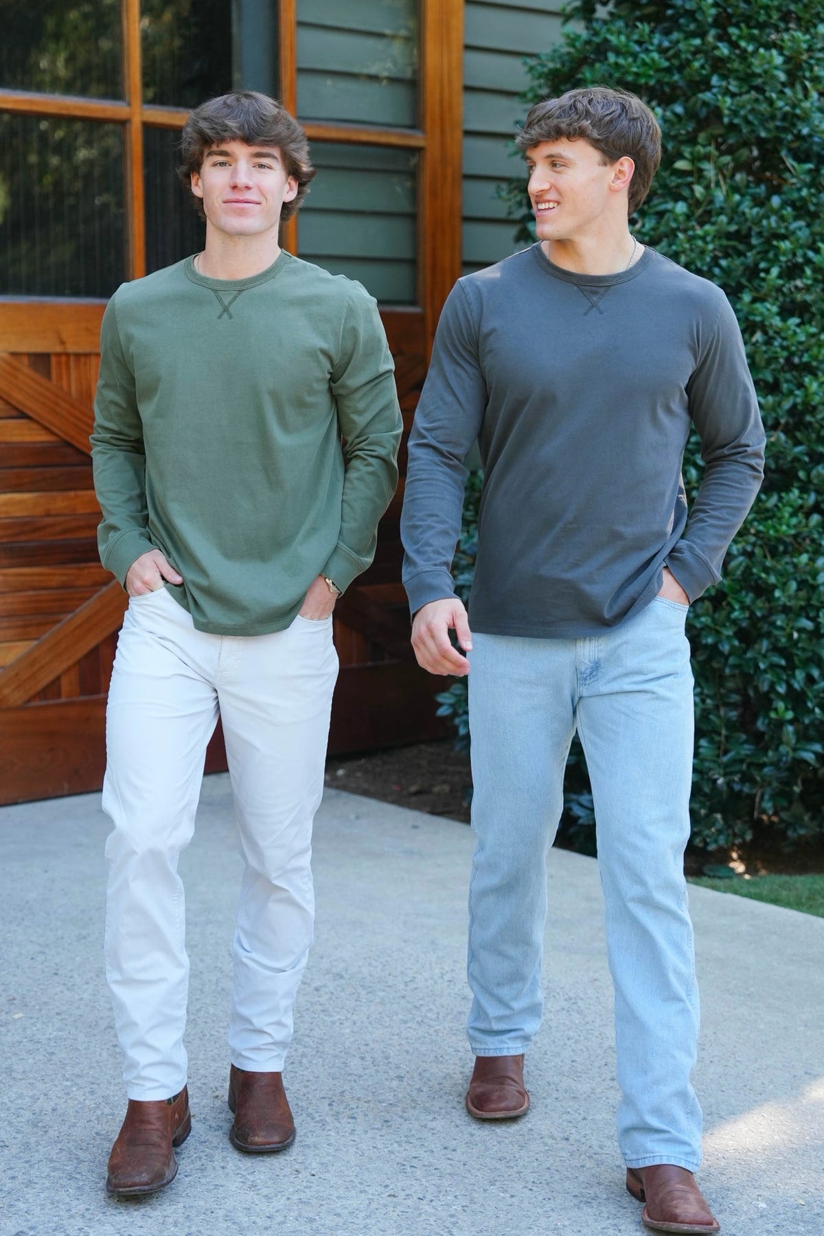 two men posing outdoors in long sleeve  charcoal and green tee shirts 