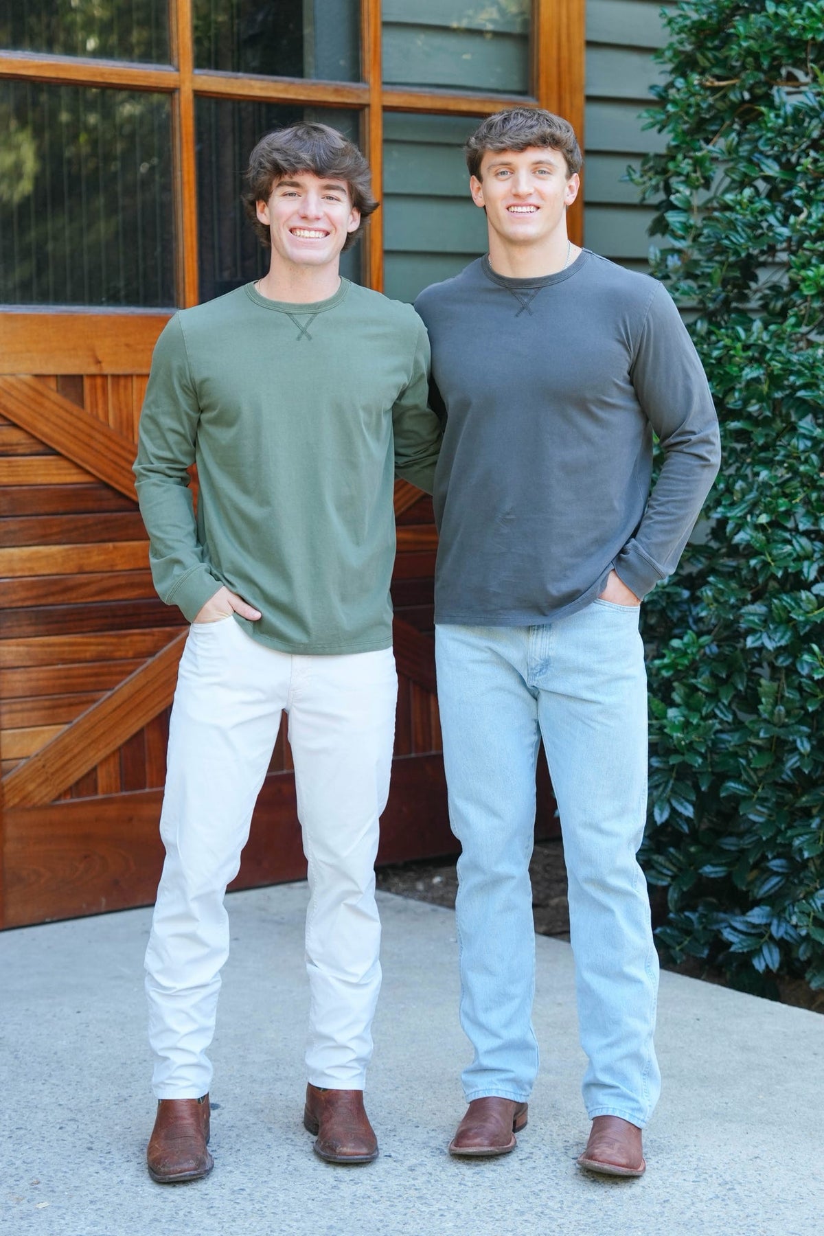 two men posing outdoors in long sleeve  charcoal and green tee shirts 