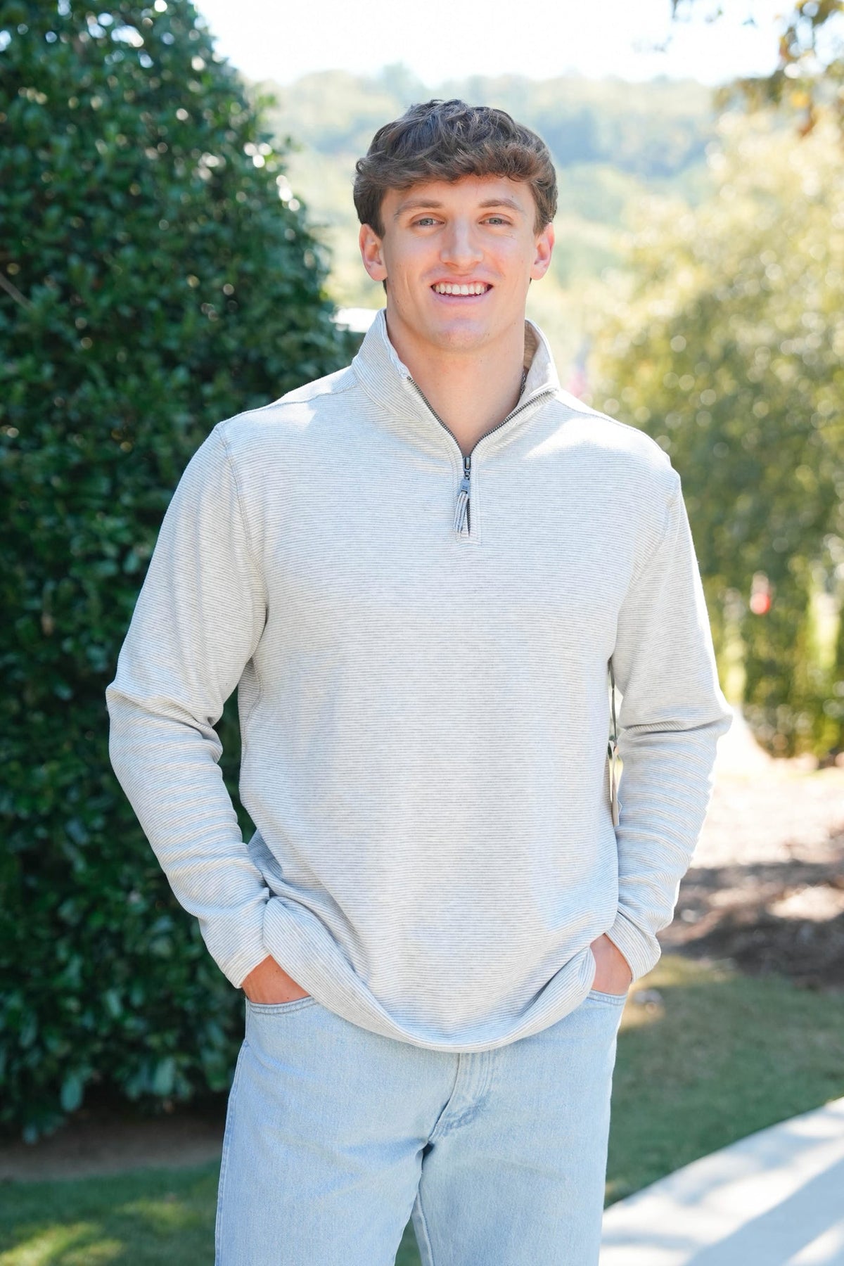 man in a heathered grey quarter zip outside 