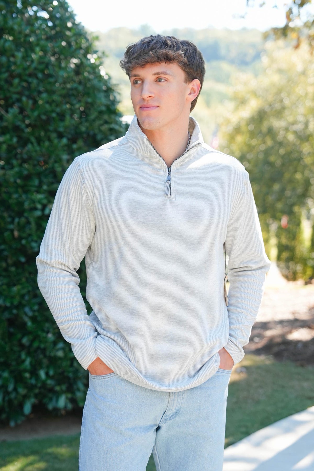 man in a heathered grey quarter zip outside 