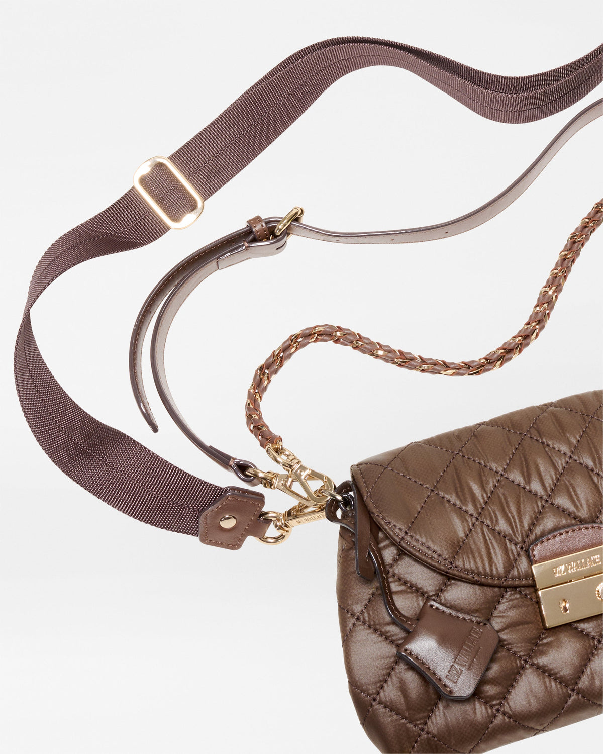 A brown quilted shoulder bag with a wide adjustable brown fabric strap, a braided chain detail, and gold-tone hardware, shown on a clean white background.