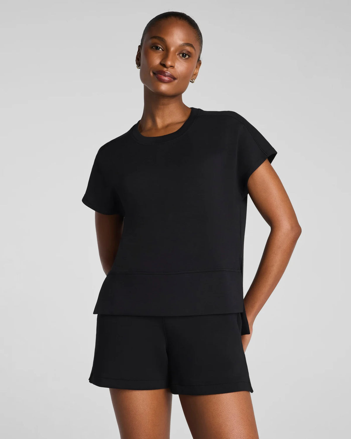 Woman wearing a black outfit on a gray background