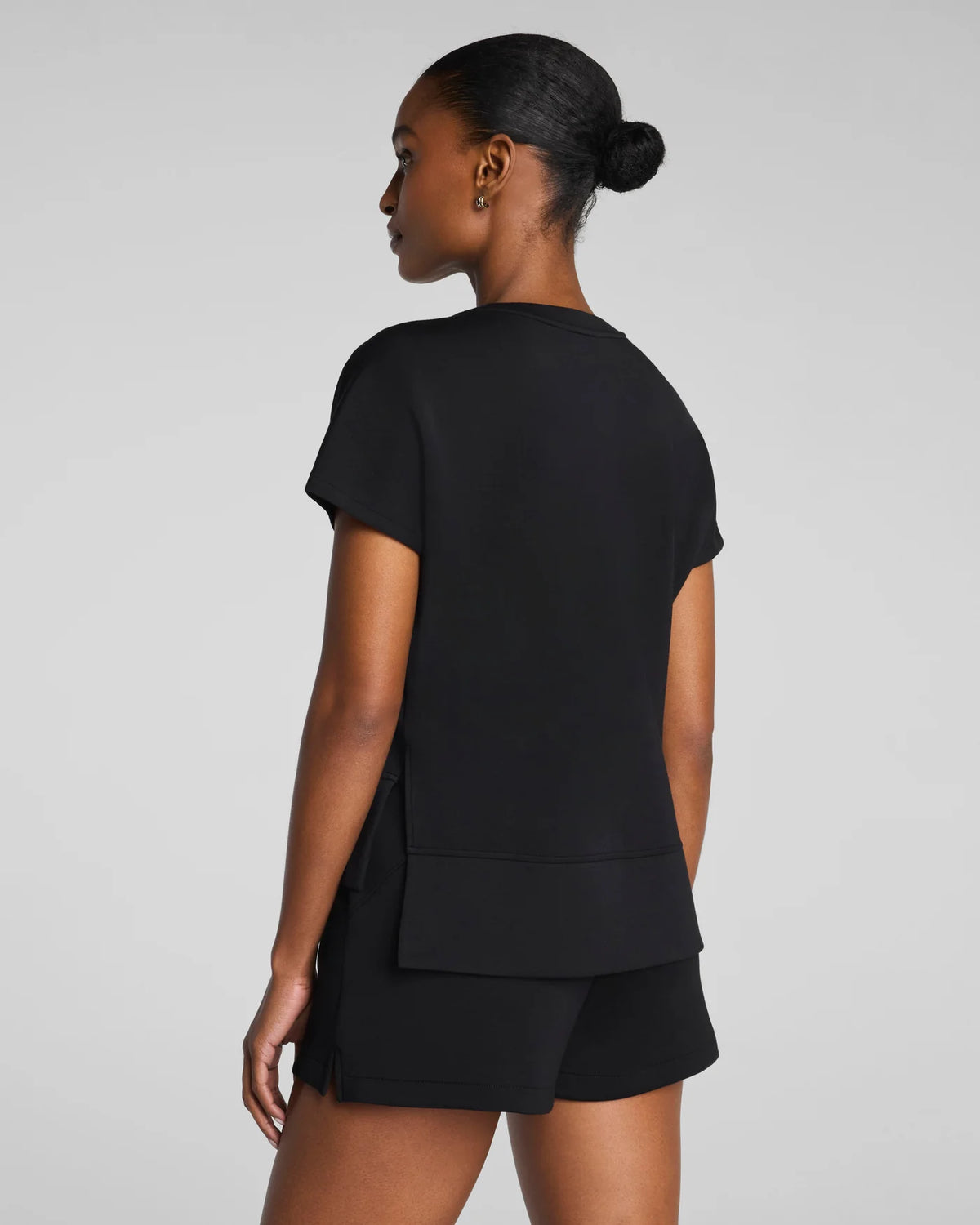 Woman wearing a black outfit on a gray background