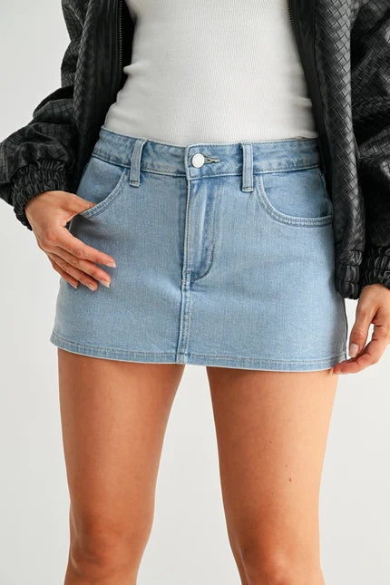 Light blue denim skirt worn by a person on a plain background