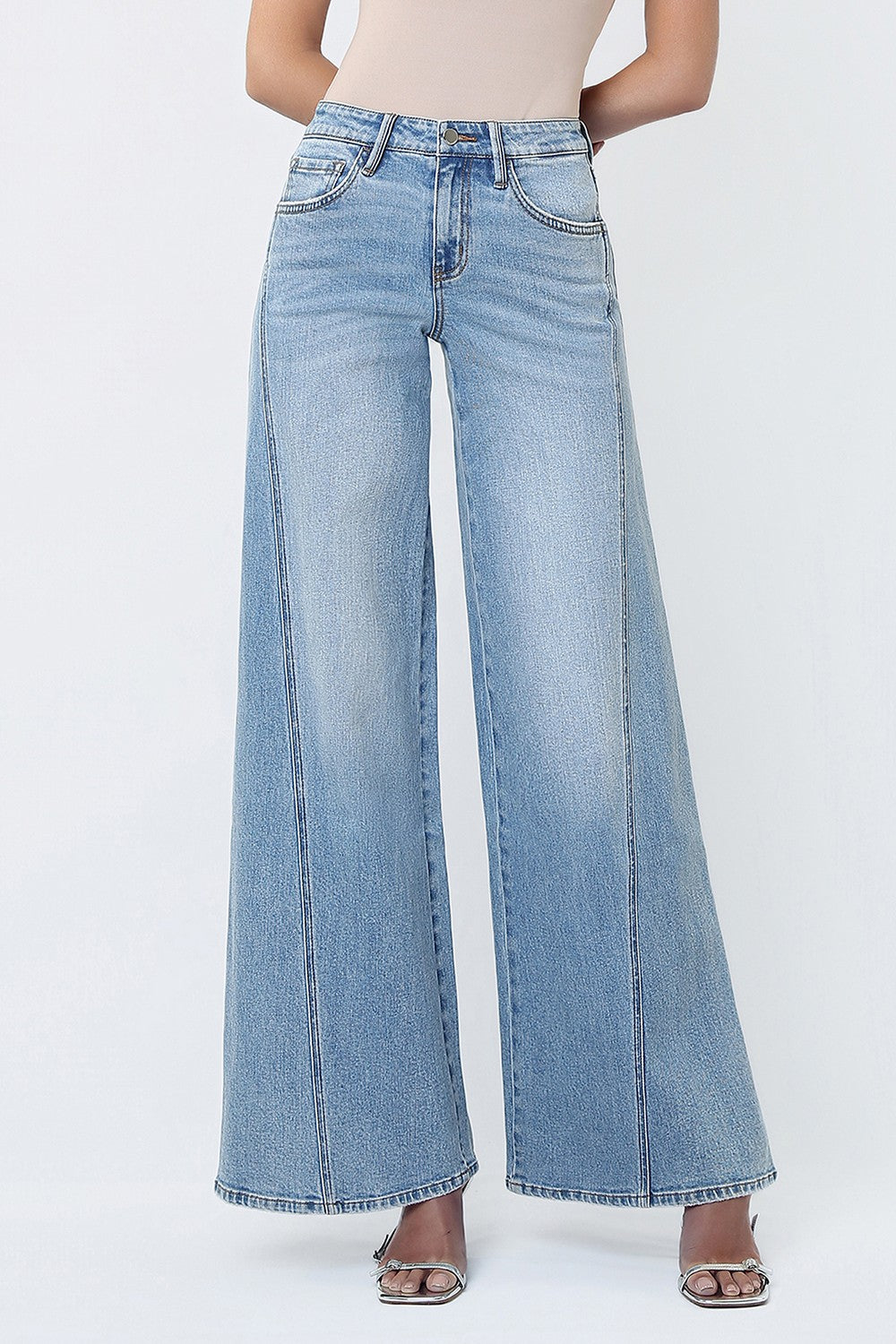woman standing against a white background modeling a wide leg pair of jeans