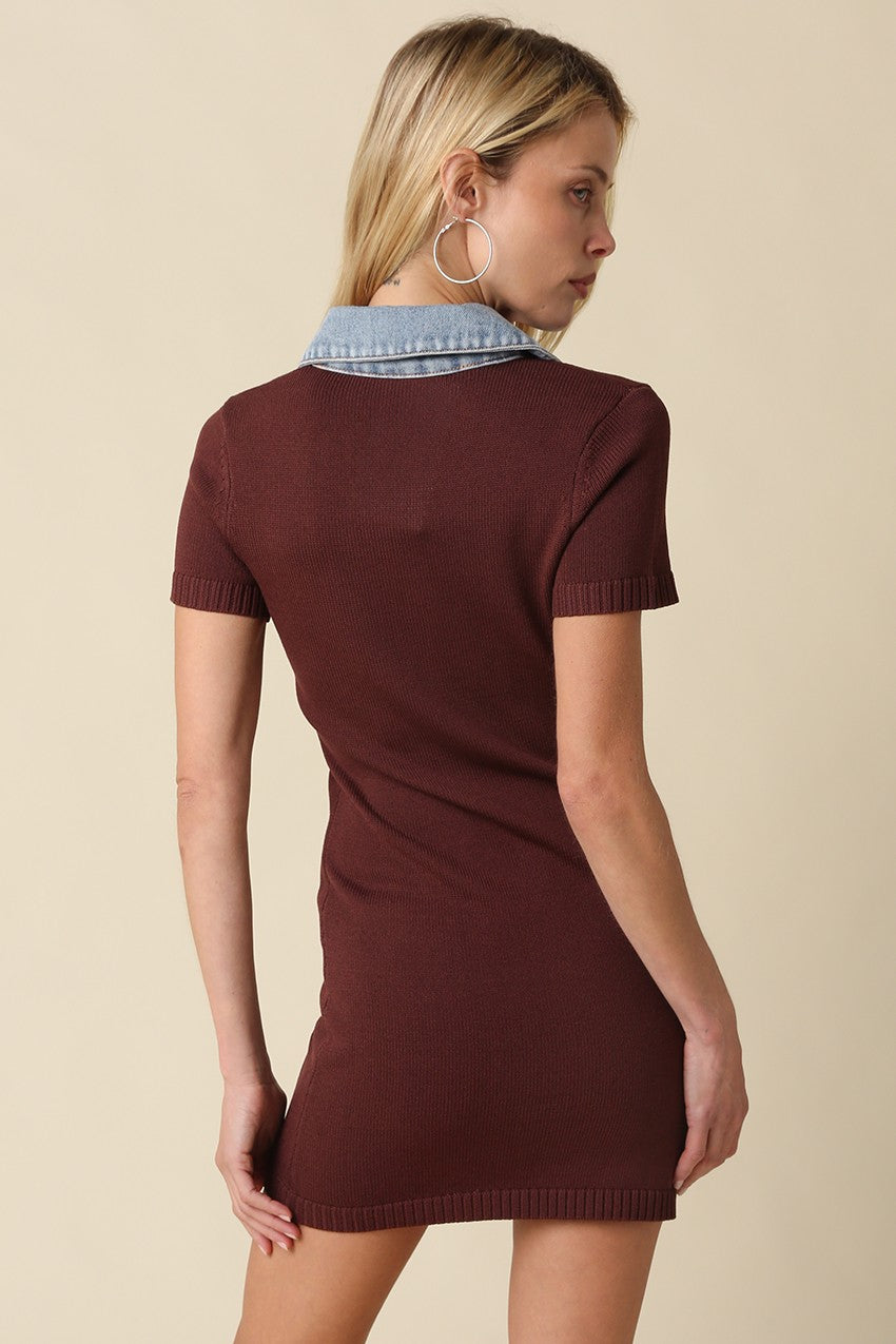 A woman shown from the back wearing a short-sleeve burgundy knit mini dress with a light blue denim collar, set against a solid beige background.