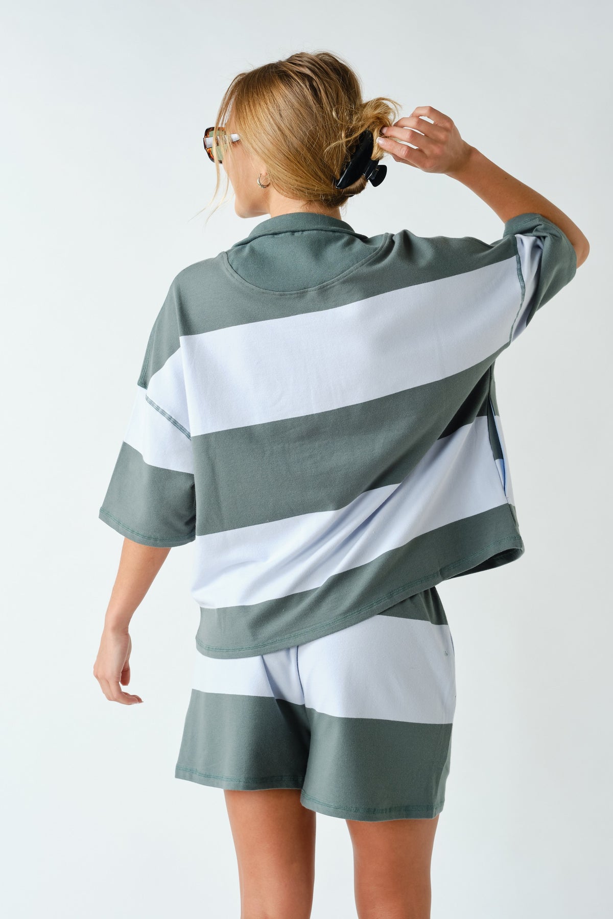 Woman wearing a striped shirt and shorts on a white background