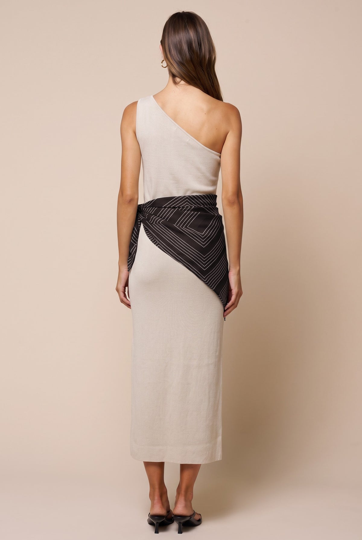 woman modeling tan dress with black scarf around waist 