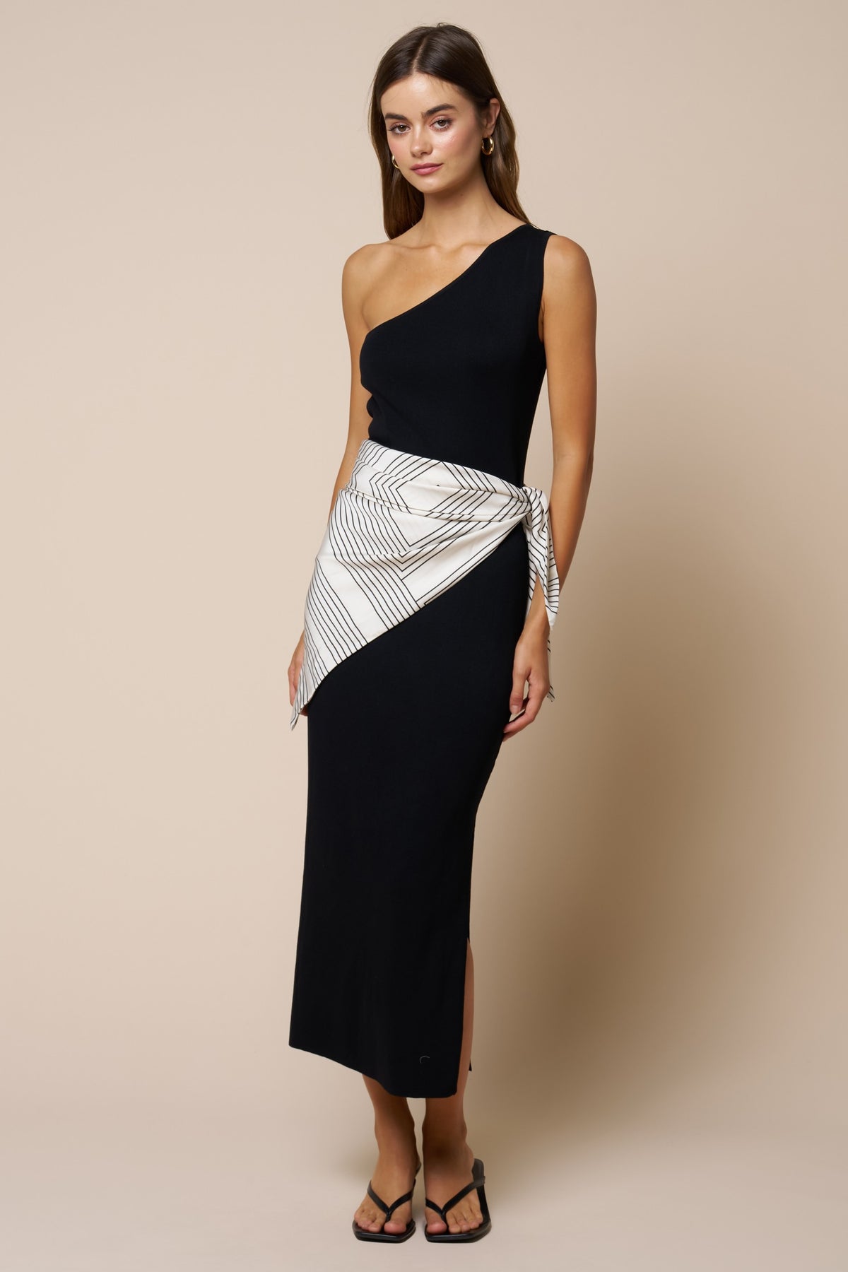 woman modeling black dress with white scarf around waist 