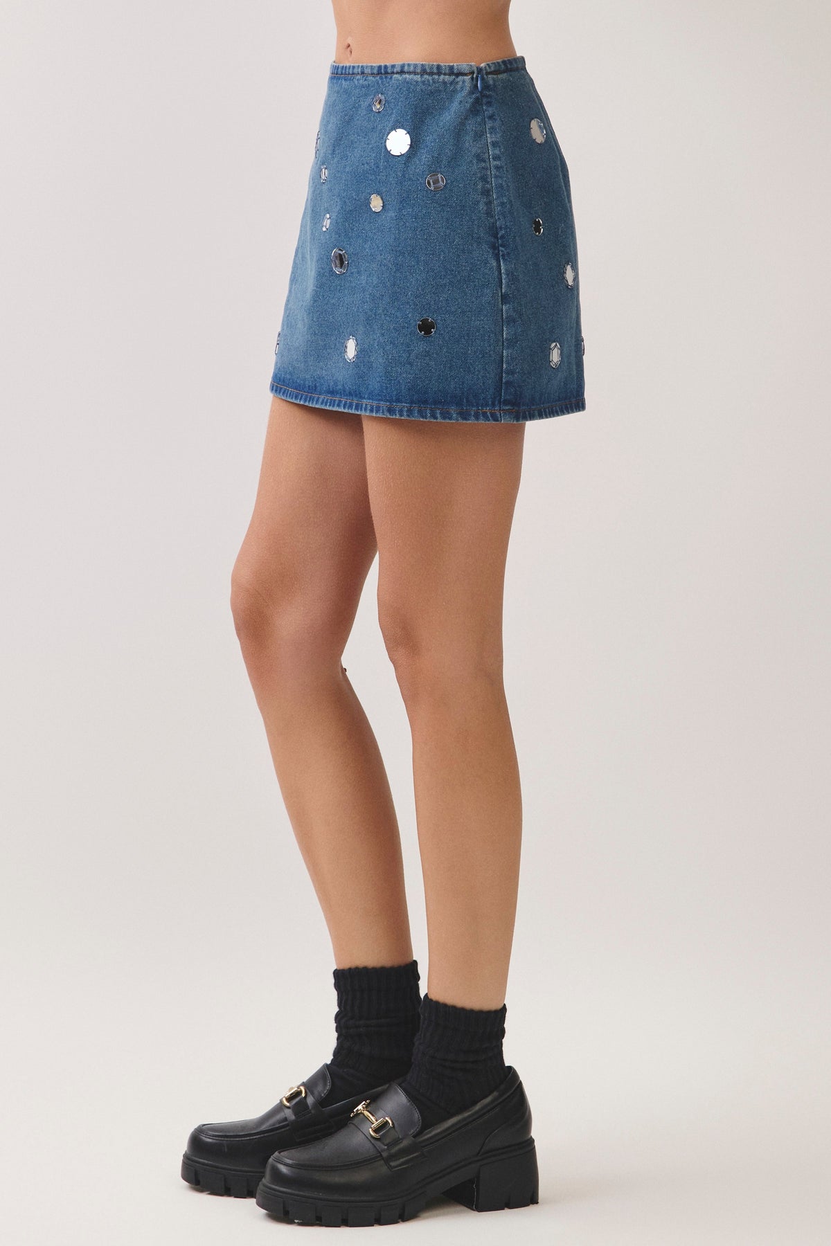woman standing on white background wearing denim set