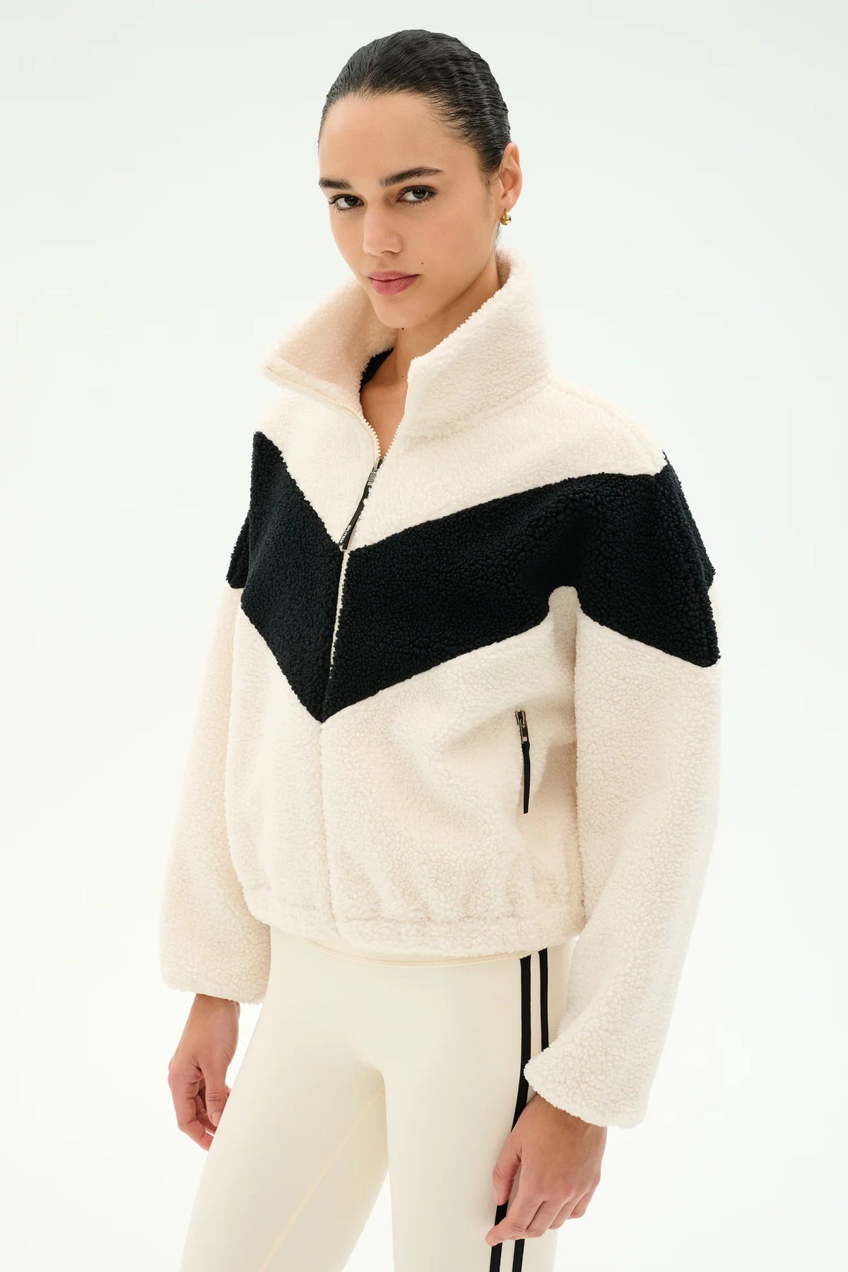 Woman modeling cream and black jacket with cream leggings