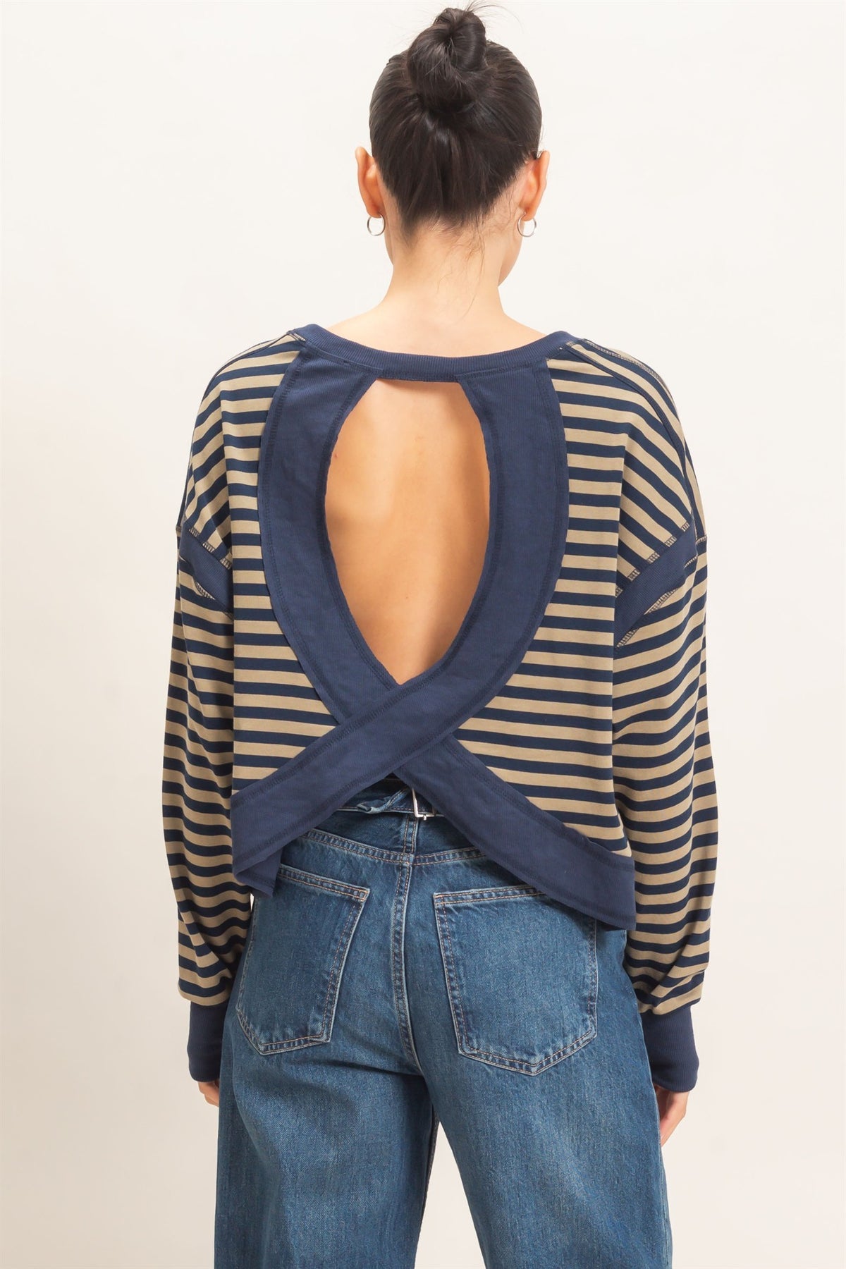 a woman showing the back of her shirt modeling the openness of the back
