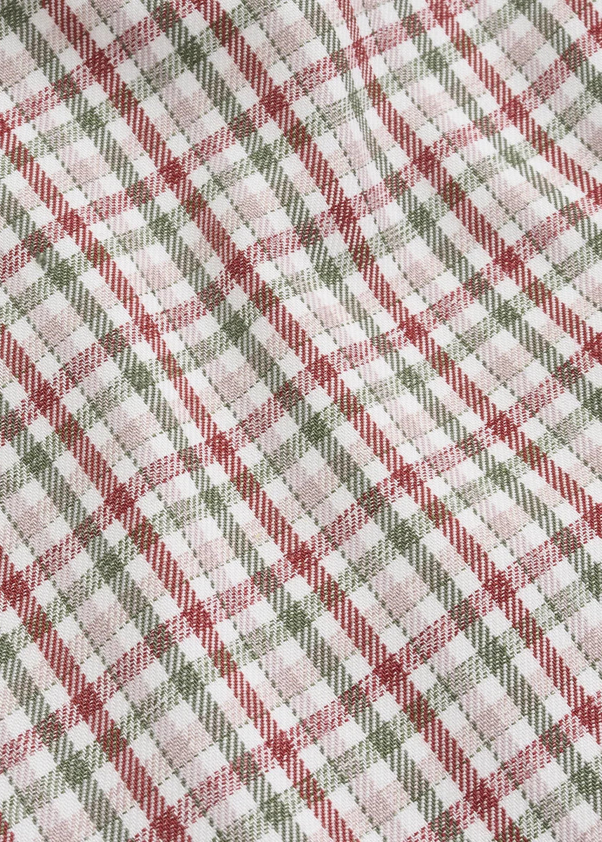 A close-up of a plaid fabric pattern with diagonal stripes in muted red, olive green, and light pink over a white background.