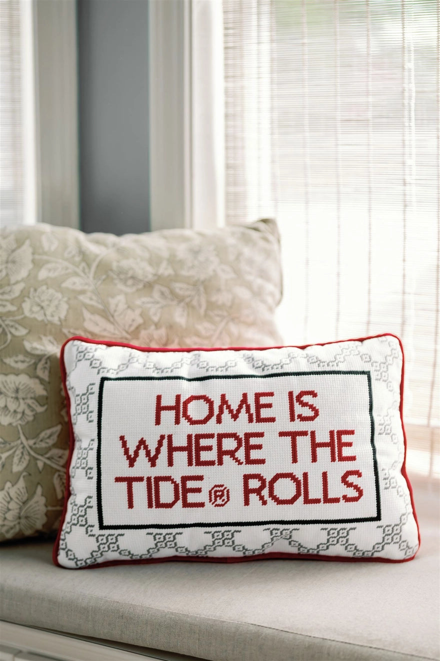 Decorative pillow with 'Home is where the tide rolls' text on a couch.