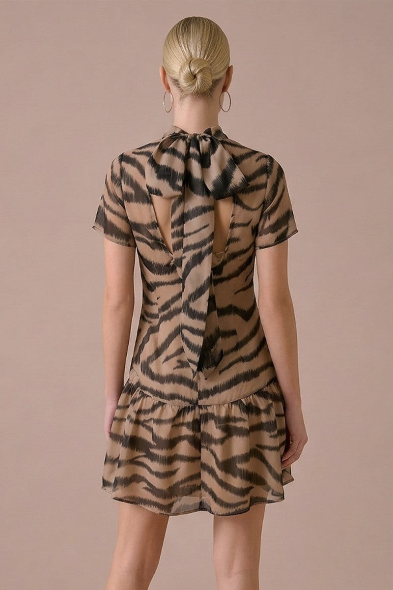 Woman wearing a tiger print dress with a plain background