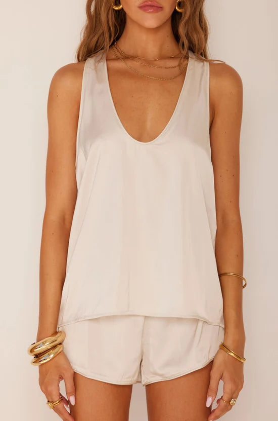 woman modeling white tank top and shorts on white background