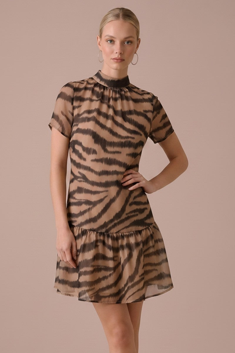 Woman wearing a tiger print dress against a beige background