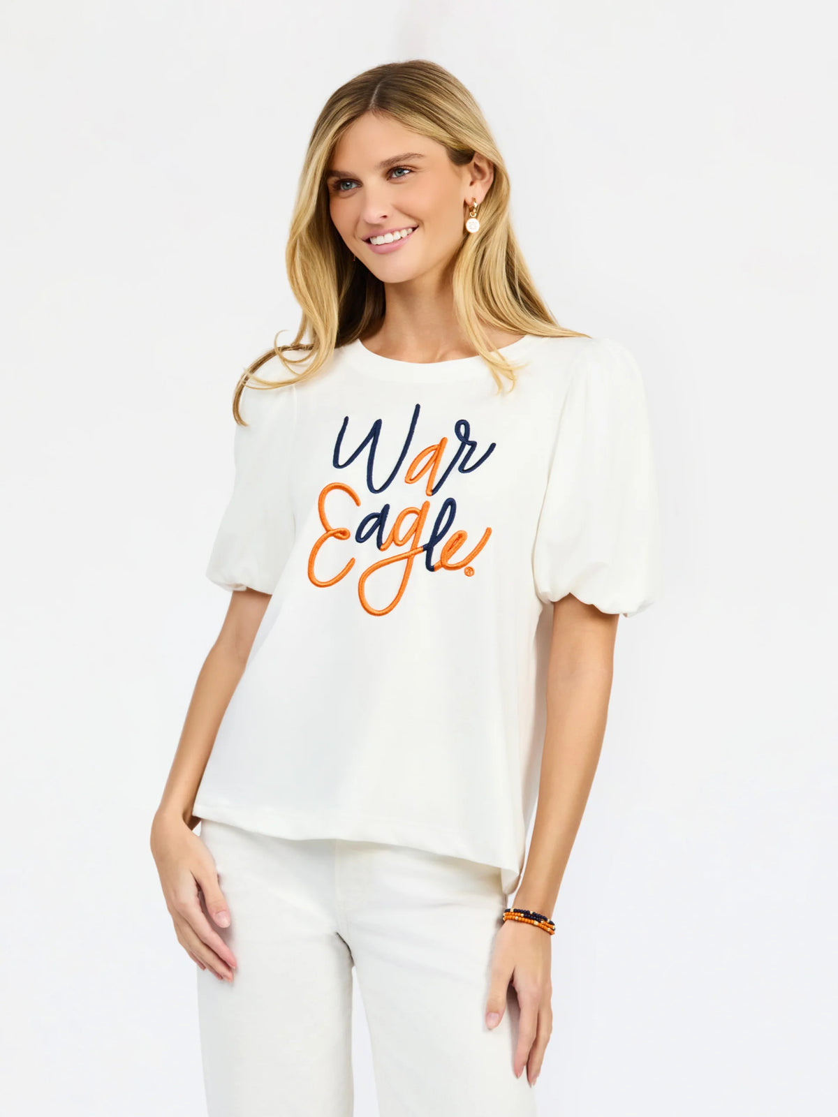 woman modeling a white puff sleeve tee with orange and blue embroidered "war eagle" on the front 