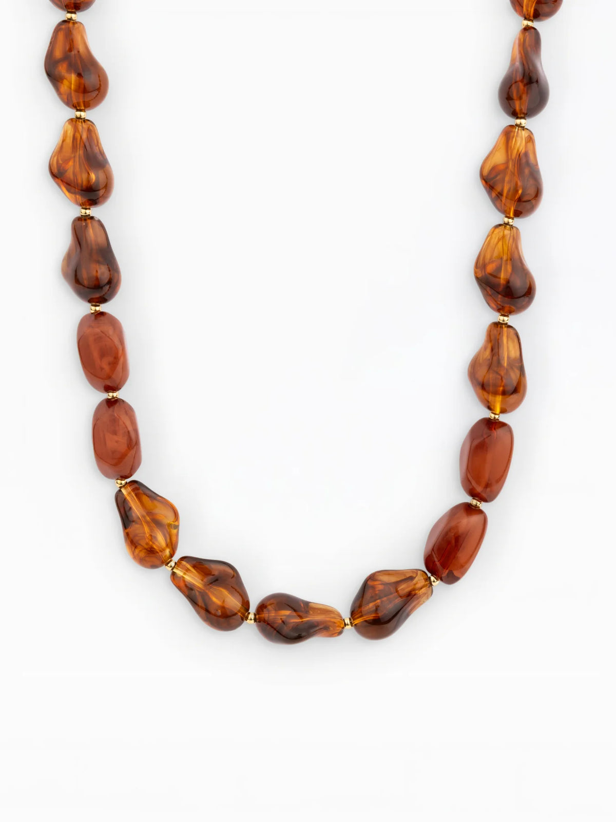 A brown tortise beaded necklace with irregular, teardrop-shaped translucent beads separated by small gold spacer rings, shown against a plain white background.