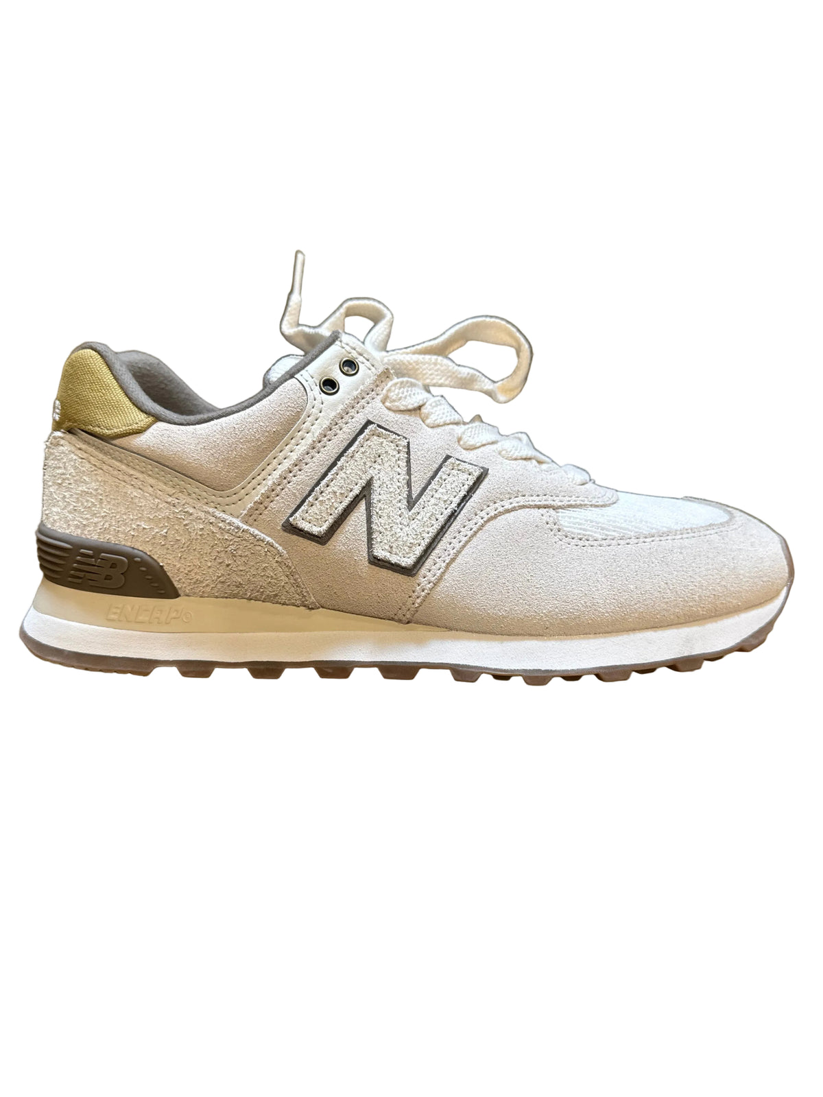 A New Balance sneaker in a metallic champagne gold and silver glitter finish, featuring a large silver 'N' logo on the side, white laces, and a beige midsole.