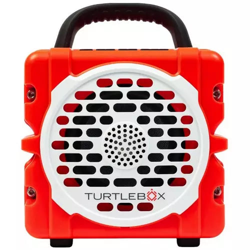 A portable TurtleBox speaker in bright orange-red and white, featuring a black carrying handle on top, a circular front grille, and the TurtleBox logo printed on the front.