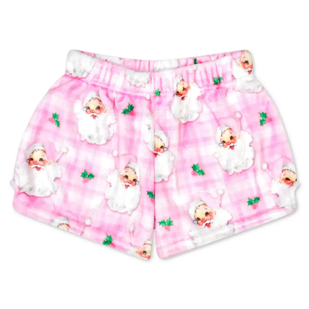 Pink plaid pajama shorts with a repeating pattern of Santa Claus and small green holly leaves, shown flat against a white background.