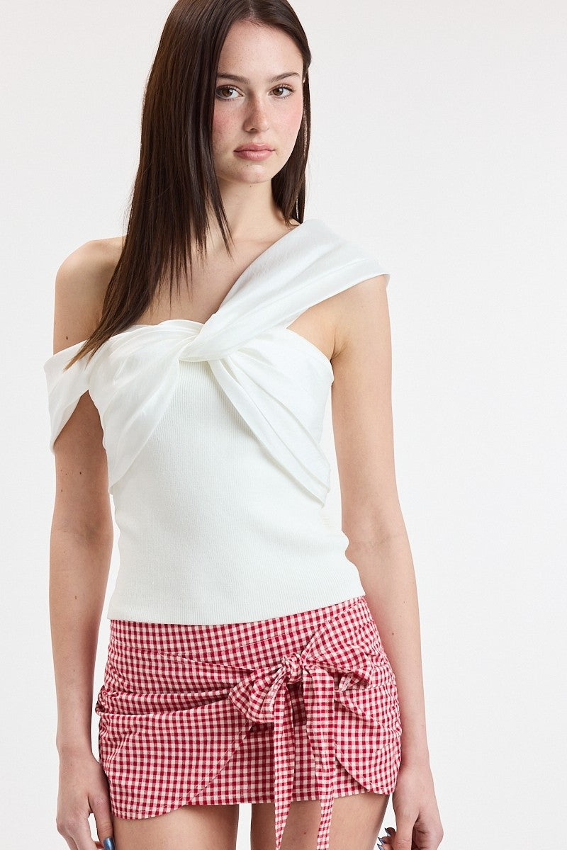 Woman wearing a white top and red checkered skirt on a white background